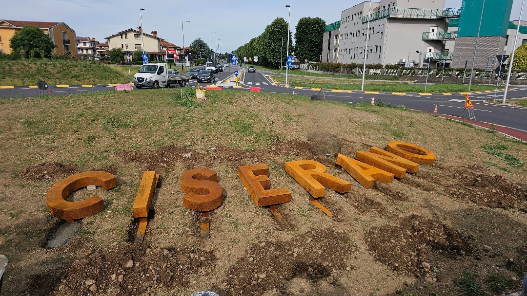Le lettere in acciaio corten della scritta Ciserano durante la posa